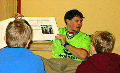 Green Guy reading to kids