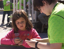 MOE student teaching local child at Dupont Riverfest